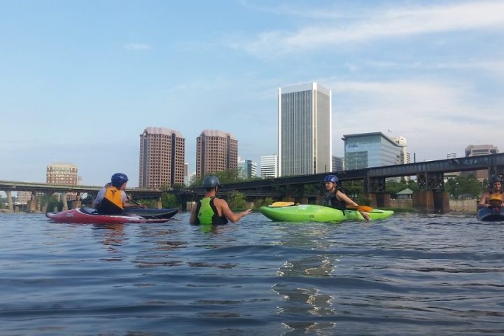 a group of people rowing a boat in a body of water