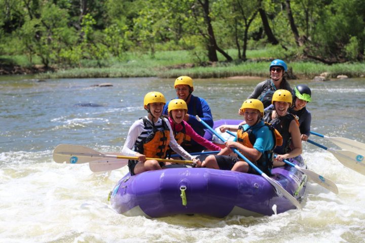 a group of people riding on a raft in a body of water
