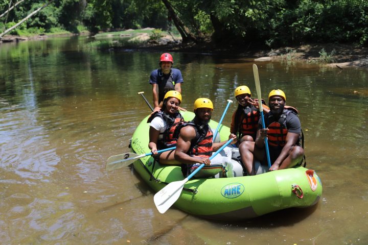 a group of people riding on the back of a boat in the water