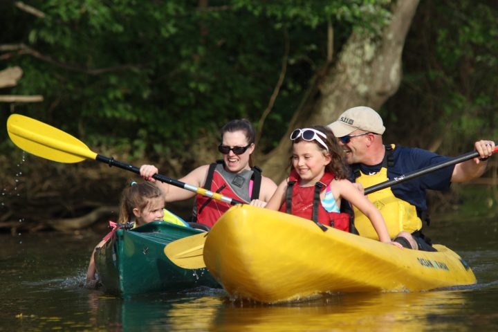 a group of people riding on a raft in a pool of water