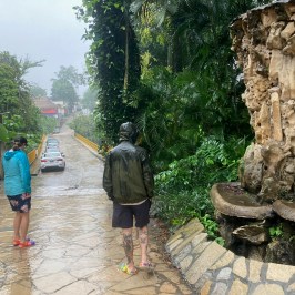 a group of people standing next to a stone wall