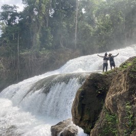 a man standing next to a waterfall