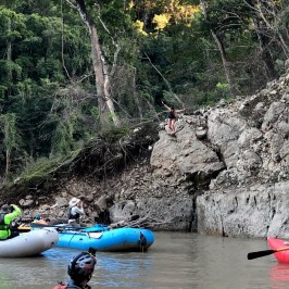 a group of people rowing a boat in the water