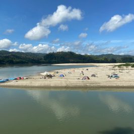 a group of people on a beach near a body of water