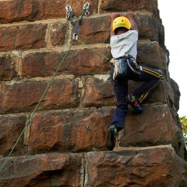 Young Boy Climbing a Rock Wall