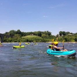 a group of people riding on the back of a boat in the water