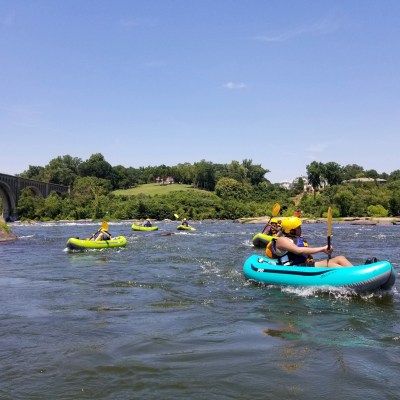 a group of people riding on the back of a boat in the water