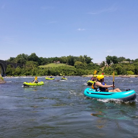 a group of people riding on the back of a boat in the water