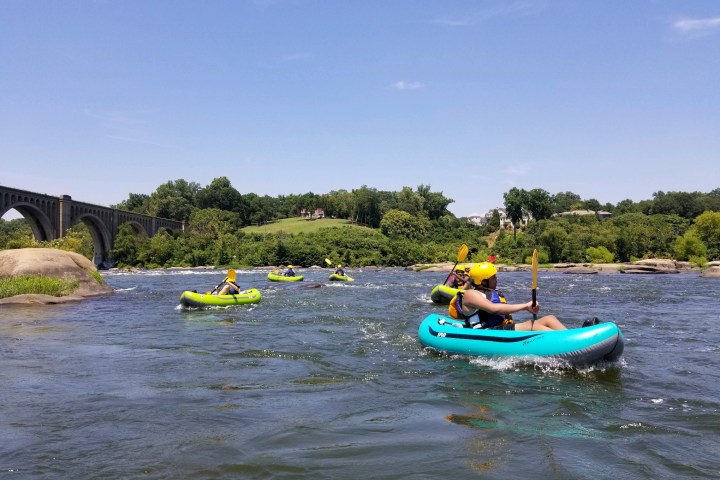 a group of people riding on the back of a boat in the water
