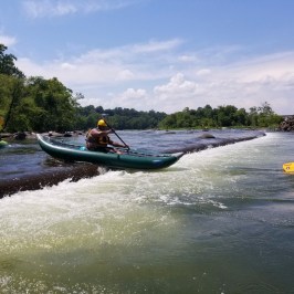 a group of people riding on the back of a boat in the water
