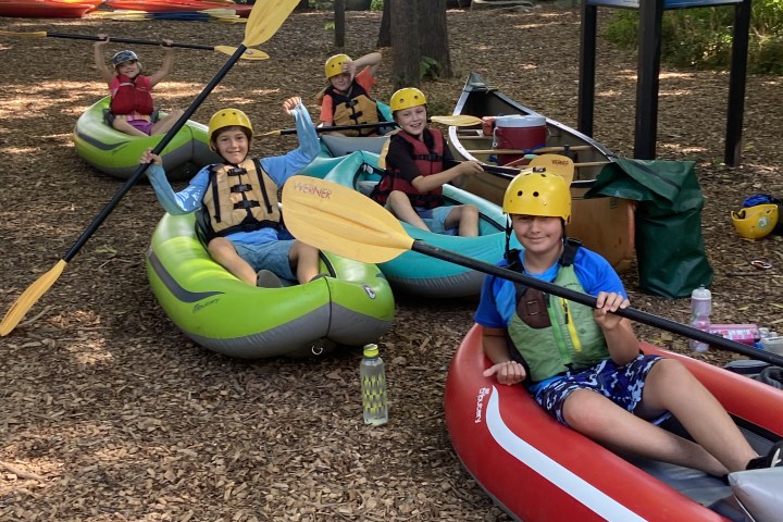 a group of people lying on the ground in kayaks