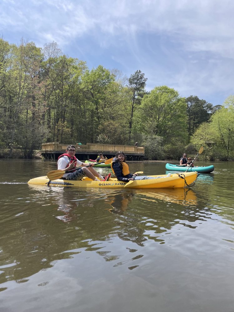 a group of people riding on the back of a boat in the water