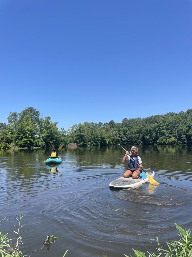 a woman kneeling on a paddle board